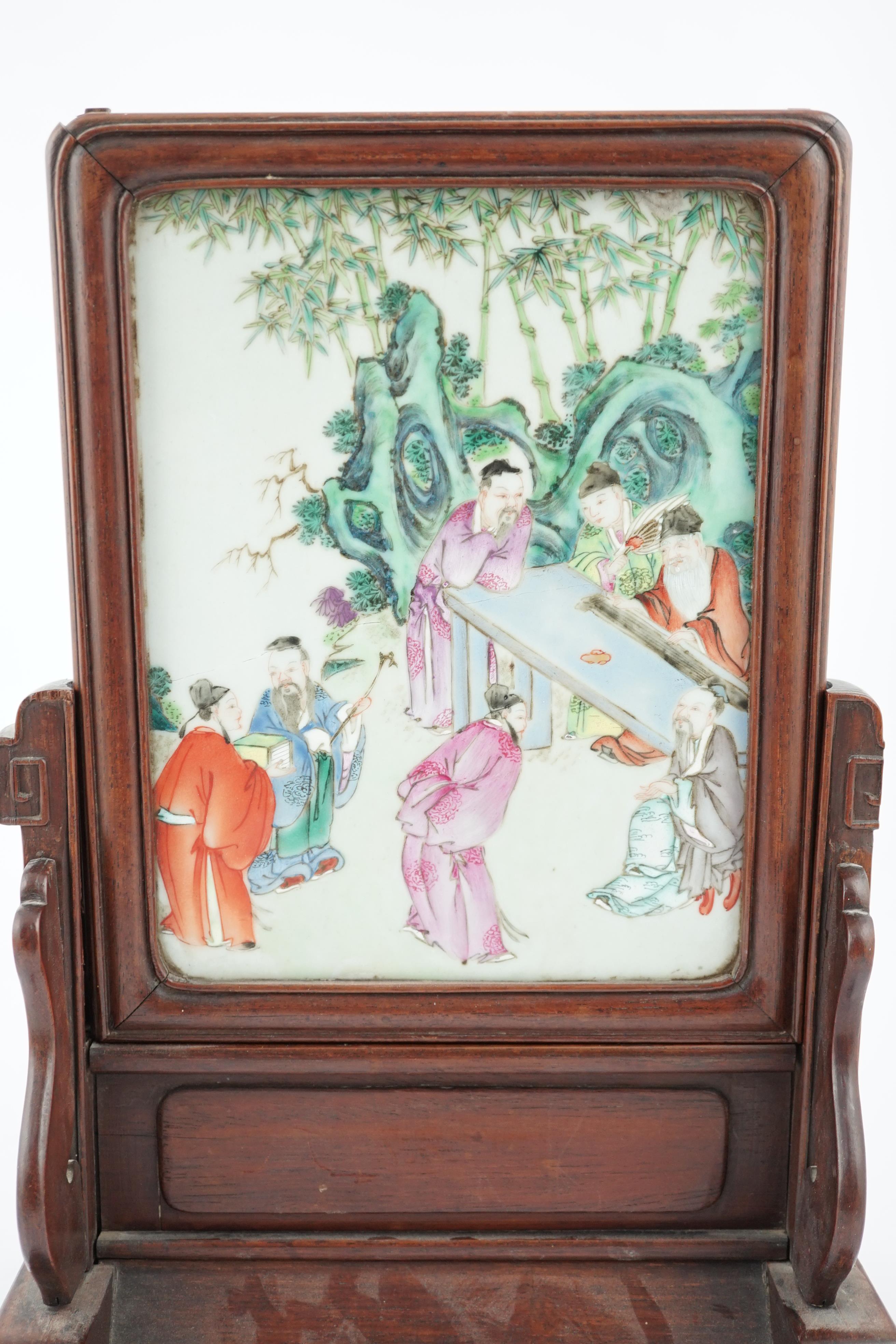 A Chinese famille rose porcelain mounted hongmu framed table screen, 19th century, some damage